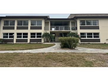 Exterior view of condo building with landscaping and walkway at 4712 Marine Pkwy # 103, New Port Richey, FL 34652