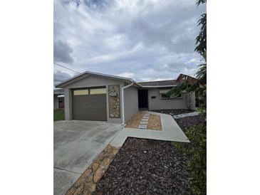 Single-story home with attached garage and stone walkway at 5052 Blue Heron Dr, New Port Richey, FL 34652