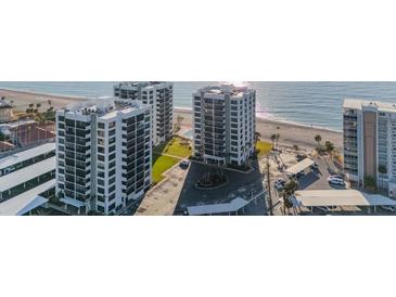 Aerial view of two beachfront high-rise buildings with parking and ocean views at 629 Alhambra Rd # 604, Venice, FL 34285