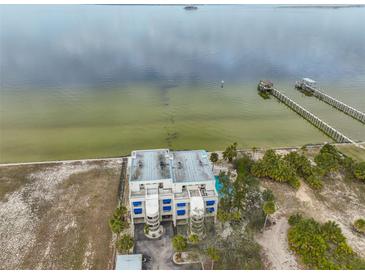 Aerial view of waterfront property with a building, pool, and boat docks at 6504 Surfside Blvd # 5, Apollo Beach, FL 33572