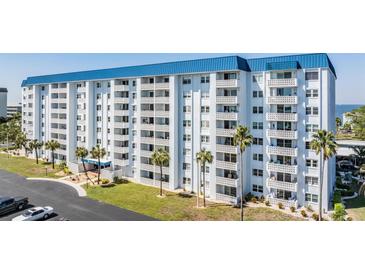 Condo building's exterior, blue roof, and landscaping at 7 Elgin Pl # 502, Dunedin, FL 34698