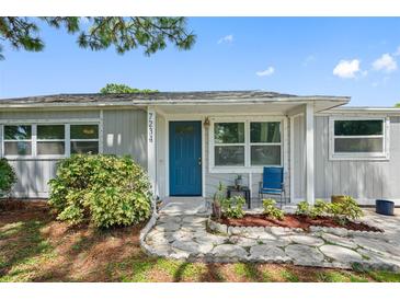 Charming single story home with a blue door and landscaped front yard at 7234 12Th N St, St Petersburg, FL 33702