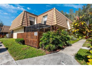 Tan two-story townhome with wood fence and tropical landscaping at 12746 Wood Trail Blvd, Tampa, FL 33625