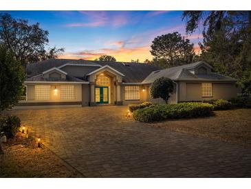 Attractive single-story home with a large driveway and landscaping at 1454 Brigadier Dr, Spring Hill, FL 34608