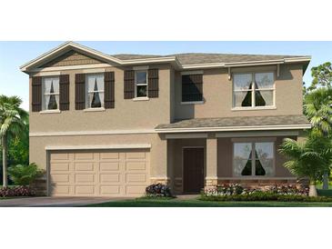 Two-story house with beige siding, brown accents, and a two-car garage at 1712 Tahitian Sunrise Dr, Plant City, FL 33565