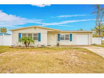 Ranch style home with white brick facade, blue shutters, and a well-maintained lawn at 5810 Town N Country Blvd, Tampa, FL 33615