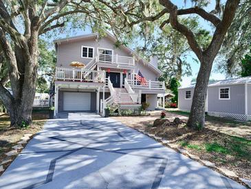 Two-story home with a large deck and a spacious driveway at 9934 Peninsular Dr, Gibsonton, FL 33534