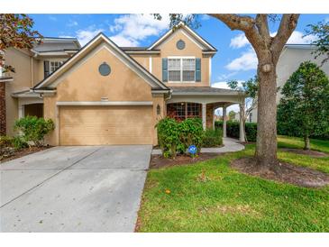 Two-story house with tan siding, two-car garage, and landscaped lawn at 10112 Haverhill Ridge Dr, Riverview, FL 33578