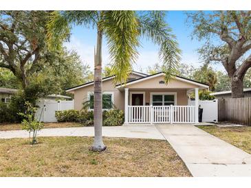 Charming home with a well-manicured lawn, palm tree, and a white picket fence surrounding the front porch at 2429 Park N St, St Petersburg, FL 33710