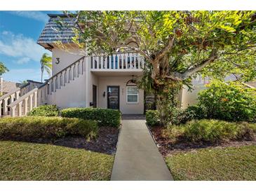 Two-story condo building with landscaped grounds and walkway at 301 Cordova Grn, Seminole, FL 33777