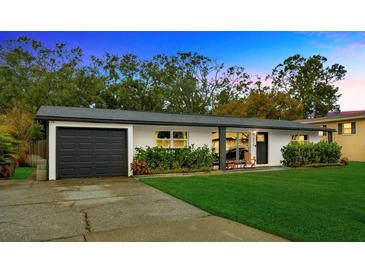 Updated Ranch home with a modern facade, attached garage, and manicured lawn at 4519 S Hesperides St, Tampa, FL 33611