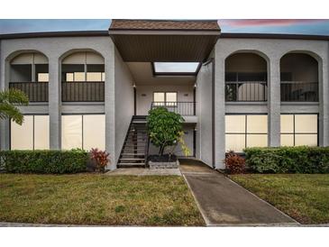 Two-story building exterior with walkway and landscaping at 7701 Starkey Rd # 105, Seminole, FL 33777