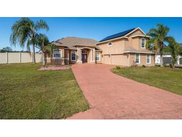 Two-story house with solar panels, large driveway, and palm trees at 8131 Spring Forest Ln, Wesley Chapel, FL 33544