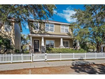 Two-story house with front porch, stone accents, and white picket fence at 10515 Fenceline Rd, New Port Richey, FL 34655