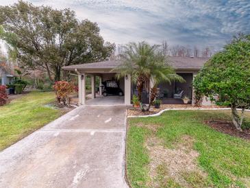 Golf cart garage, screened porch, and landscaped yard at 2022 Hawkhurst Cir, Sun City Center, FL 33573