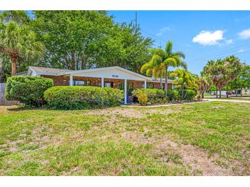 Brick ranch home with lush landscaping and mature trees at 8296 15Th N Way, St Petersburg, FL 33702