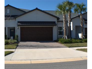 Two-story house with brown garage door and landscaped yard at 16843 Forge Surf St, Land O Lakes, FL 34638