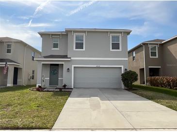 Charming two-story home with a well-maintained front yard, a two-car garage, and a welcoming entrance at 16949 Secret Meadow Dr, Odessa, FL 33556