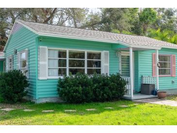 Charming light teal home with white shutters, landscaping, and walkway at 2600 46Th S St, Gulfport, FL 33711