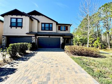 Two-story house with a two-car garage and landscaping at 4899 Isola Ct, Wesley Chapel, FL 33543