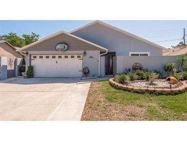 Attractive single-story home with a two-car garage and landscaped front yard at 735 Bonnie Blvd, Palm Harbor, FL 34684