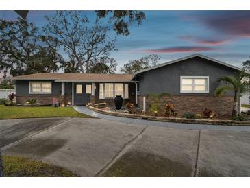 Charming single-story home boasts a stone facade, beautiful landscaping, and a welcoming entrance at 12840 Sophia Cir, Largo, FL 33774