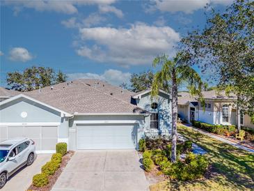 Attractive villa with 2-car garage, lush landscaping, and a peaceful neighborhood setting at 2071 Sifield Greens Way # 103, Sun City Center, FL 33573