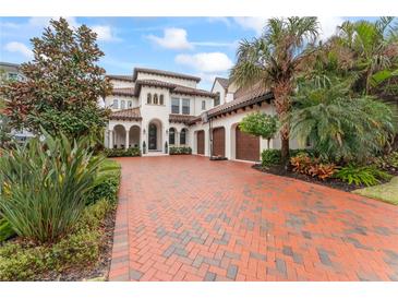 Luxury two-story home with brick driveway, lush landscaping, and three-car garage at 4902 Carranza Ct, Tampa, FL 33616