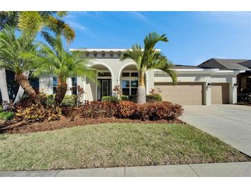 House exterior featuring a two-car garage and lush landscaping at 6920 Crestpoint Dr, Apollo Beach, FL 33572