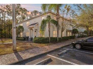 Two-story townhome with light-colored siding, landscaping, and a paved walkway at 9626 Charlesberg Dr, Tampa, FL 33635