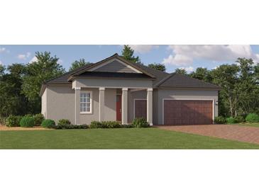 One-story home with gray siding, brown garage door, and a red front door at 31656 Cardinal Yard Dr, San Antonio, FL 33576