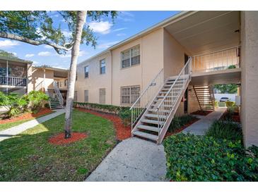 Charming condo exterior featuring manicured landscaping and exterior stairways at 4725 Christa Ct # 331, Tampa, FL 33614