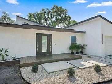 Modern home with white exterior, dark brown accents, and a landscaped front yard at 513 Hand Ave, Sarasota, FL 34232