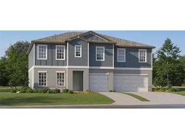 Two-story home with gray siding, stone accents, and a three-car garage at 11915 Blue Diamond Trl, Parrish, FL 34219