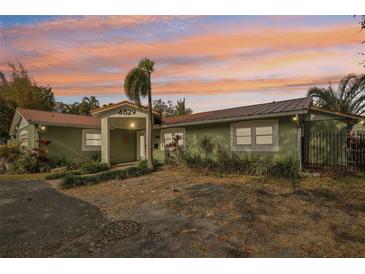 Charming single-story home with lush landscaping, front yard, and a colorful sunset sky at 4829 W San Miguel St, Tampa, FL 33629