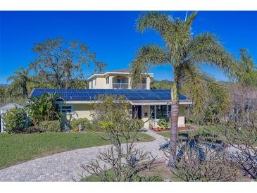 House exterior with solar panels, palm trees, and paved driveway at 783 Placido Ne Way, St Petersburg, FL 33704