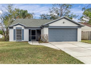 One-story house with gray garage door and well-maintained lawn at 1628 Baker Rd, Lutz, FL 33559