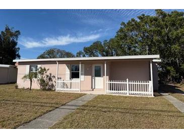 Ranch-style home with white picket fence and mature landscaping at 21480 Olean Blvd, Port Charlotte, FL 33952