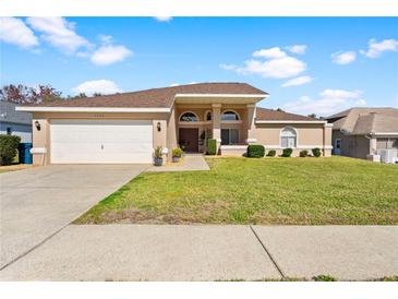 Single-story home with attached garage and well-manicured lawn at 1066 Larkin Rd, Spring Hill, FL 34608