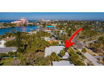 A high-angle captures a serene neighborhood with its charming homes, palm trees, and glimpses of the waterway at 3110 W De Bazan Ave, St Pete Beach, FL 33706