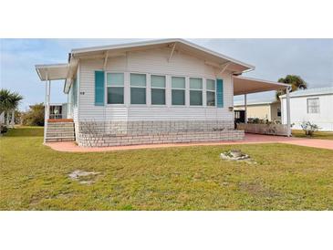 Cute updated manufactured home with carport and small front yard at 112 Saint Pierres Way, Apollo Beach, FL 33572