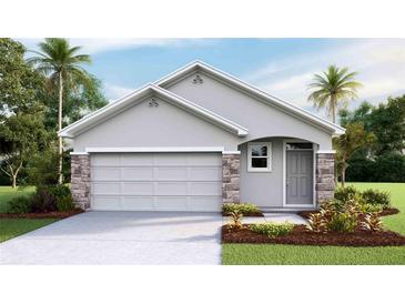 One-story home with gray exterior, stone accents, and a two-car garage at 6963 Broad River Ave, Land O Lakes, FL 34638