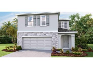 Two-story house with gray siding, stone accents, and a two-car garage at 6987 Broad River Ave, Land O Lakes, FL 34638