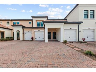 Exterior view of townhouses with attached garages and brick pavers at 10043 Crooked Creek Dr # 202, Venice, FL 34293