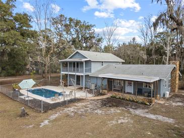 Aerial view of a home with a pool and detached barn at 12519 Fairwinds Rd, Hudson, FL 34669