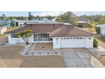 Single-story home with brown roof, white exterior, and landscaped yard at 1732 Flamingo Ln, Sun City Center, FL 33573