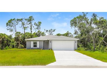 Gray house with white garage door and green lawn at 191 Prineville St, Port Charlotte, FL 33954