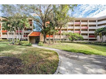 Condo building with landscaped grounds and a walkway at 3062 Eastland Blvd # 405, Clearwater, FL 33761