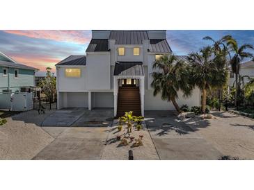 Two-story home with white exterior, metal roof, and landscaped yard at 519 Loquat Dr, Anna Maria, FL 34216