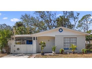 Charming brick home with a white picket fence and landscaped yard at 6811 S Hesperides St, Tampa, FL 33616